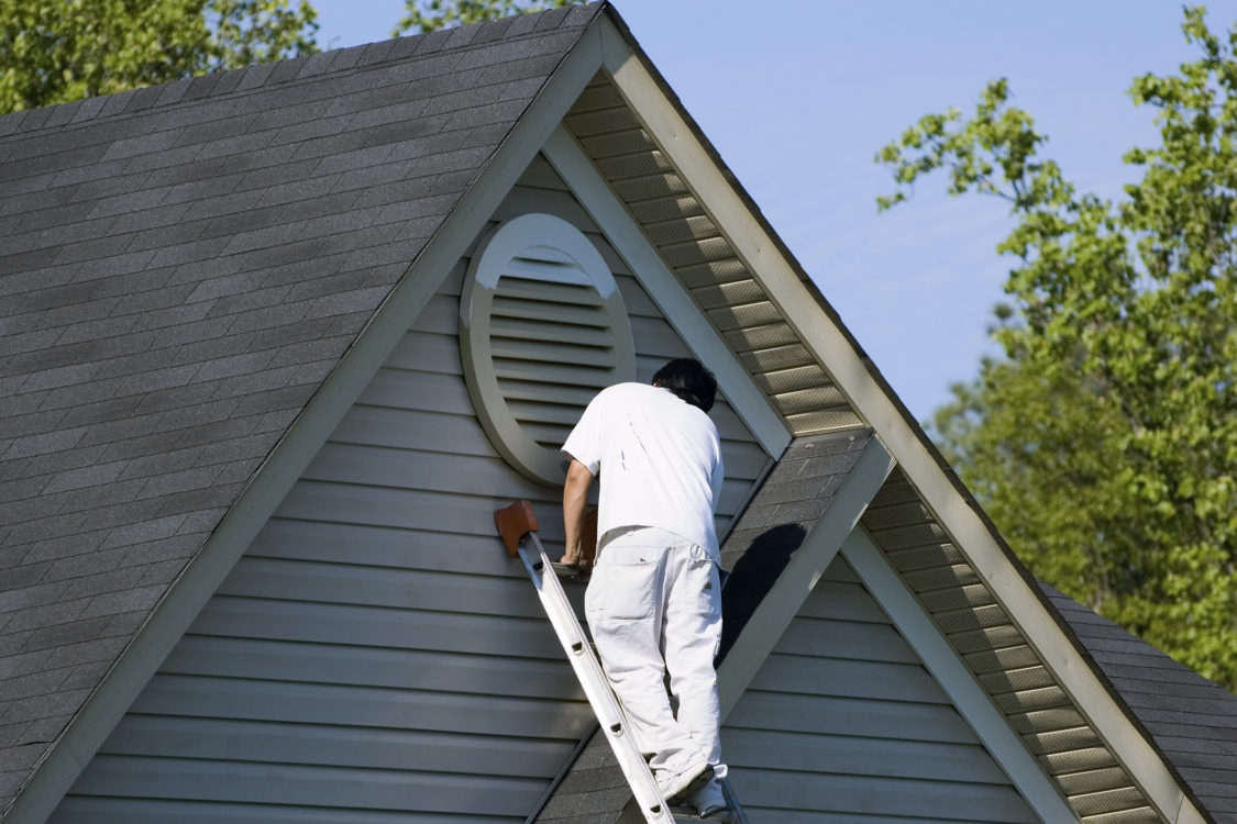 Painter working at roofline